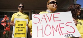 In this Sept. 24, 2010 photo, supporter Marisa Salas, right, holds a sign during a foreclosure and eviction rally at the home of Carlos Moreno in Menlo Park, Calif. Moreno has owned his home since 2006, had his home under foreclosure  since January 2010, and was served eviction notice in July 2010. His case is now pending with the bank. For most Americans at risk of losing their homes, the brutal business of foreclosure goes on. (AP Photo/Paul Sakuma)