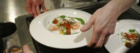 Chef Grant Achatz places a dish on a server's tray at Alinea, one of the Chicago restaurants featured in the AAA's latest restaurant guide. (AP Photo/Charles Rex Arbogast)